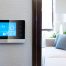 A smart thermostat positioned on a wall overlooking a modern style living room