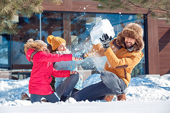 family playing in the snow